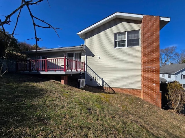 back of house with ac unit, a lawn, and a deck