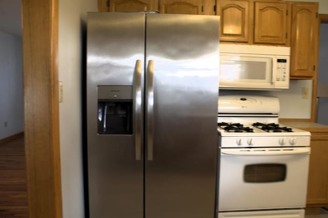 kitchen featuring white appliances, baseboards, and light countertops