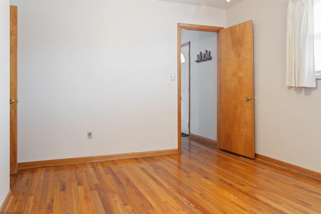 unfurnished room featuring baseboards and light wood-style floors