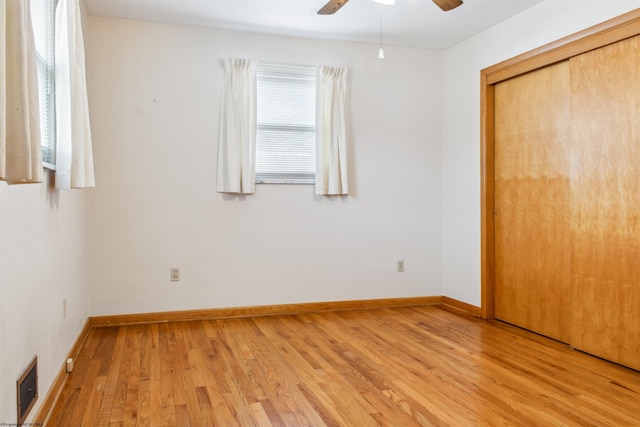 unfurnished bedroom featuring a closet, visible vents, ceiling fan, light wood-type flooring, and baseboards