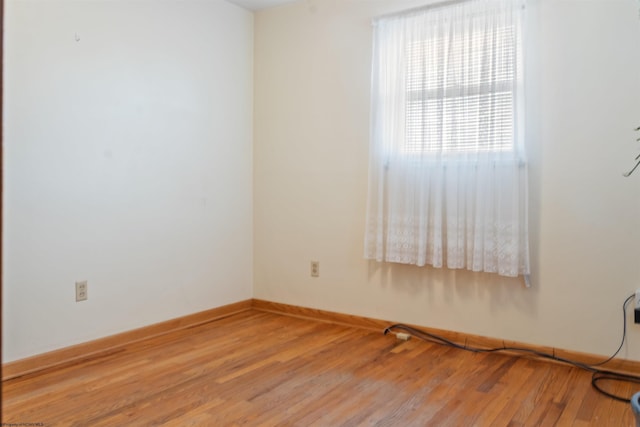 spare room featuring light wood-style flooring and baseboards