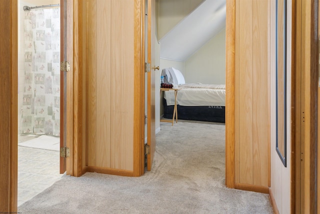 hall with lofted ceiling and carpet floors