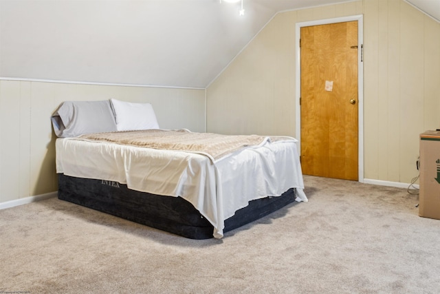 carpeted bedroom featuring lofted ceiling and baseboards