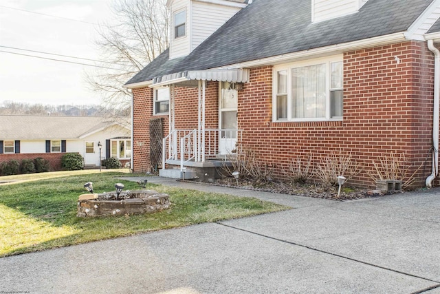 property entrance with a yard and brick siding