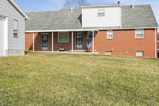 back of property with brick siding, a lawn, a porch, and a shingled roof