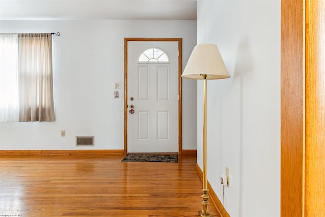 entrance foyer with wood finished floors, visible vents, and baseboards