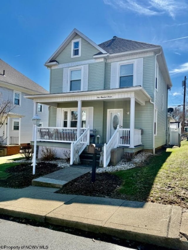 view of front of home featuring covered porch and a shingled roof