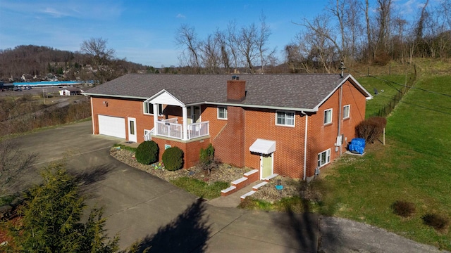 view of front facade featuring concrete driveway, brick siding, a chimney, and a front lawn