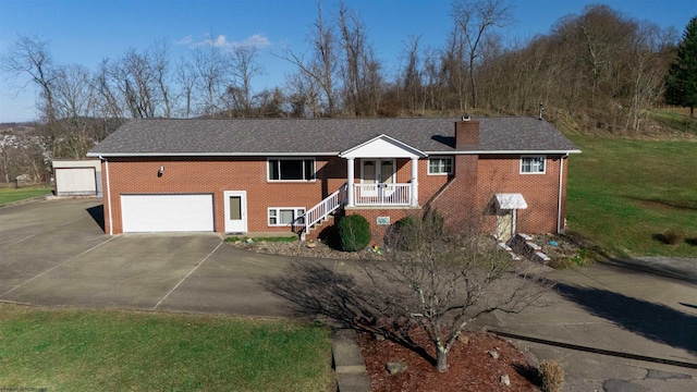 view of front facade featuring brick siding, a chimney, covered porch, driveway, and a front lawn