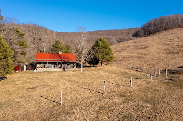 view of yard featuring an outbuilding, a rural view, and fence