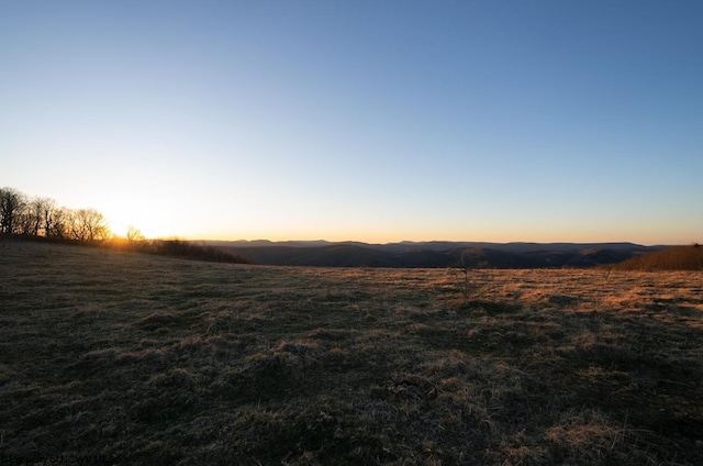 nature at dusk featuring a rural view and a mountain view