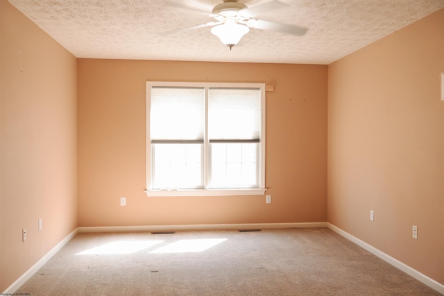 unfurnished room featuring visible vents, baseboards, ceiling fan, a textured ceiling, and carpet floors