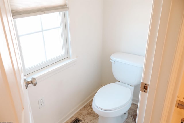 bathroom with toilet, baseboards, and visible vents