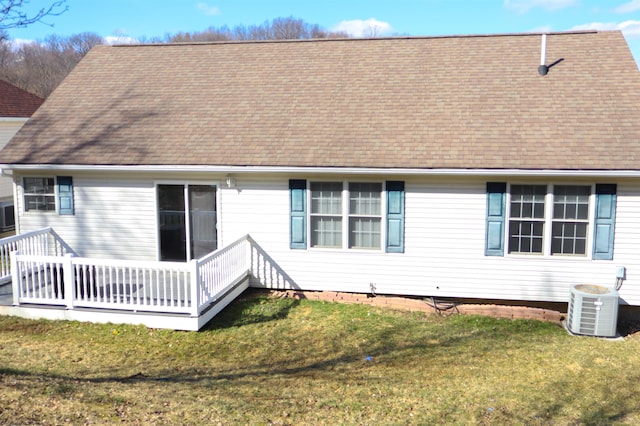 rear view of house featuring cooling unit, roof with shingles, a yard, and a deck