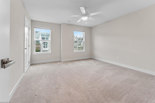 empty room featuring a ceiling fan, a wealth of natural light, carpet flooring, and baseboards