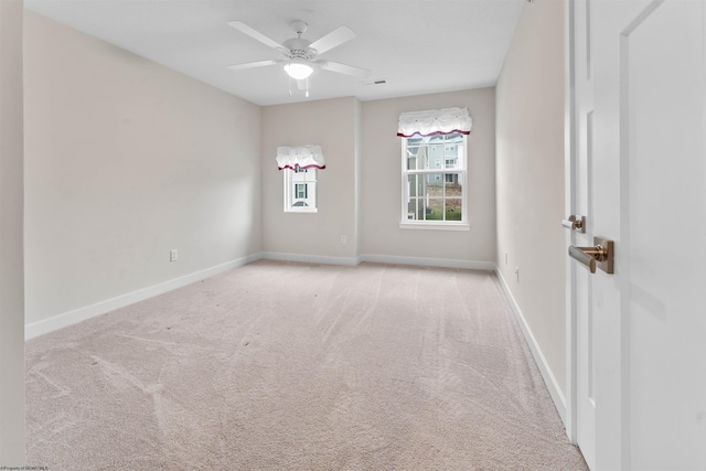 carpeted empty room featuring a ceiling fan, visible vents, and baseboards