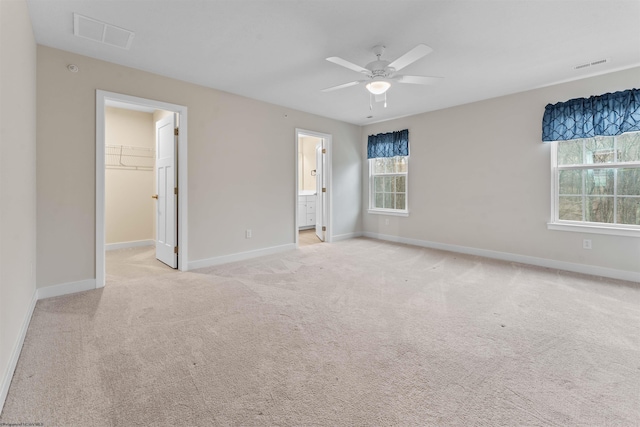 unfurnished bedroom with light carpet, visible vents, baseboards, a spacious closet, and a closet