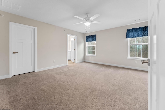 unfurnished bedroom with carpet flooring, connected bathroom, visible vents, and baseboards