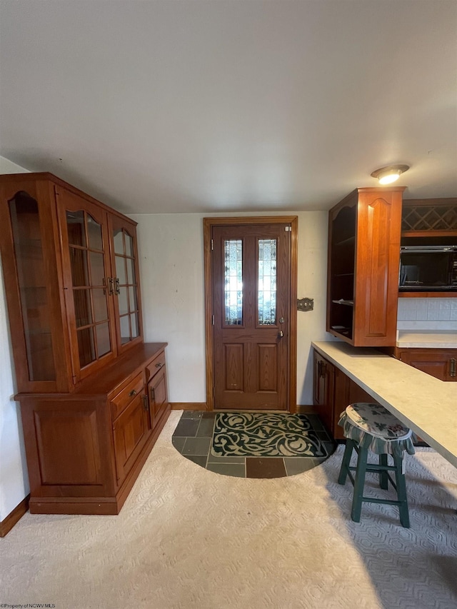 carpeted foyer with baseboards