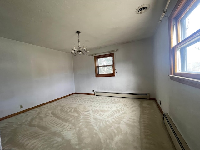 unfurnished room featuring a baseboard heating unit, a wealth of natural light, and visible vents