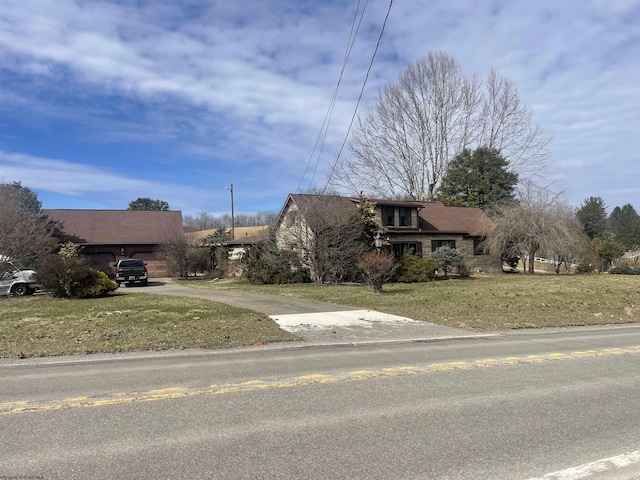 view of front facade featuring a garage, a front lawn, and concrete driveway