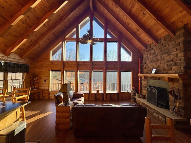 living area featuring beamed ceiling, a fireplace, wood finished floors, and wood ceiling