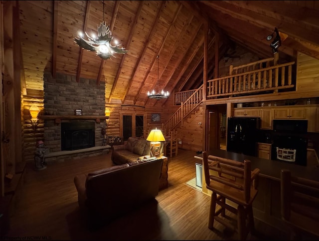 living area with wooden ceiling, stairway, beamed ceiling, a stone fireplace, and light wood-style floors