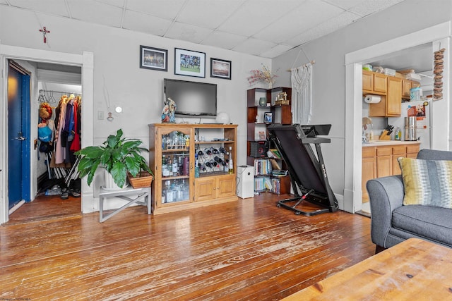 living room with a paneled ceiling and hardwood / wood-style flooring