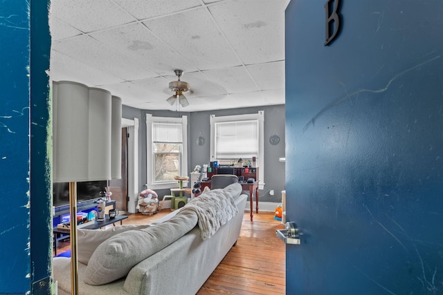 living room featuring ceiling fan, baseboards, and hardwood / wood-style flooring