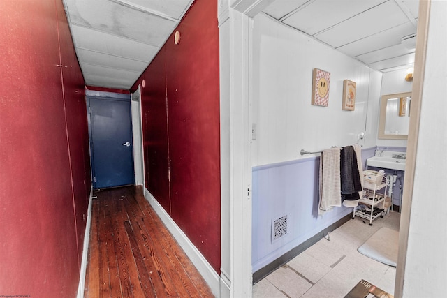 corridor with wood finished floors and visible vents