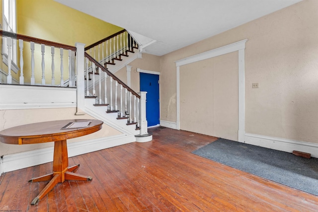 entryway featuring wood-type flooring, stairway, and baseboards