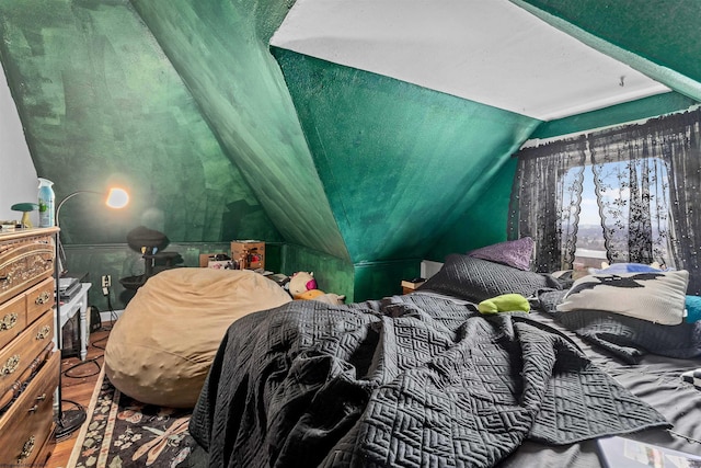 bedroom featuring lofted ceiling and wood finished floors