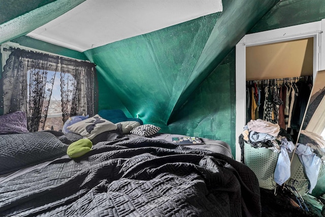 bedroom with lofted ceiling and a closet