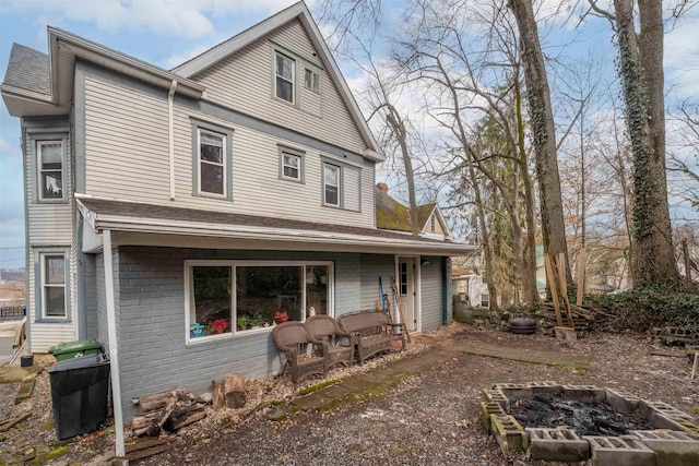 view of front facade featuring an outdoor fire pit and brick siding