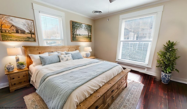 bedroom featuring ornamental molding, multiple windows, dark wood finished floors, and visible vents