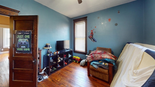 bedroom with lofted ceiling, a ceiling fan, and hardwood / wood-style floors