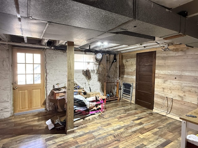 below grade area featuring wooden walls and wood finished floors