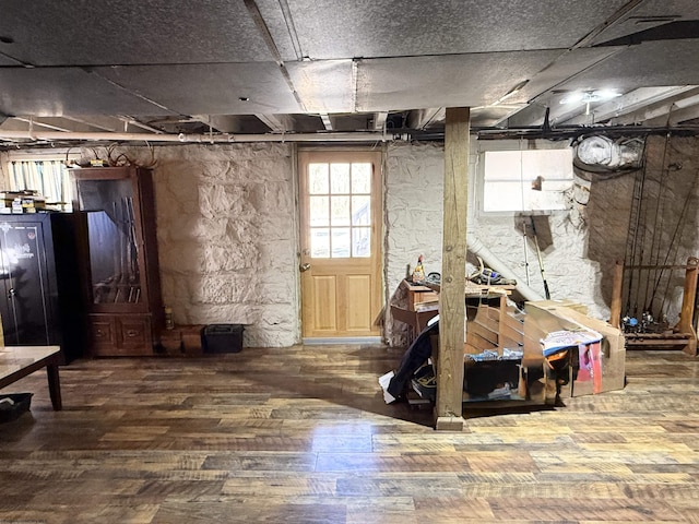 basement with black refrigerator and wood finished floors