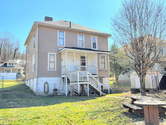 rear view of house with an outdoor structure, a yard, stairway, a shed, and a chimney