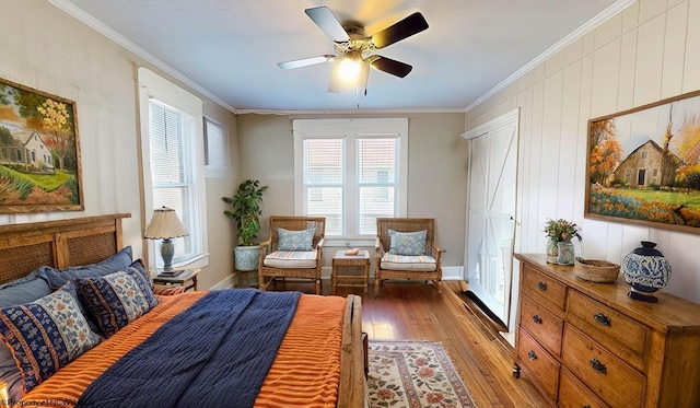 living area with ornamental molding, plenty of natural light, light wood-style flooring, and a ceiling fan