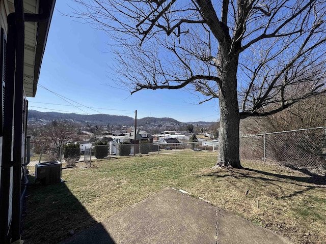 view of yard featuring cooling unit, a fenced backyard, and a mountain view