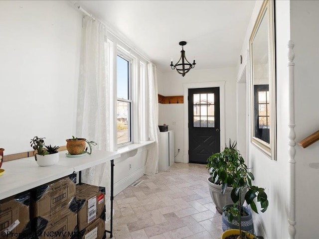 mudroom with stone finish flooring and an inviting chandelier