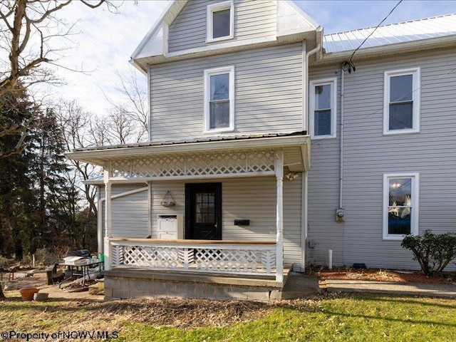 back of property with a porch