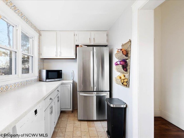 kitchen with appliances with stainless steel finishes, light countertops, and white cabinetry