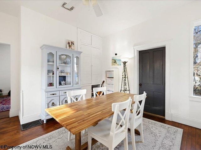 dining area featuring ceiling fan, dark wood-type flooring, visible vents, and baseboards