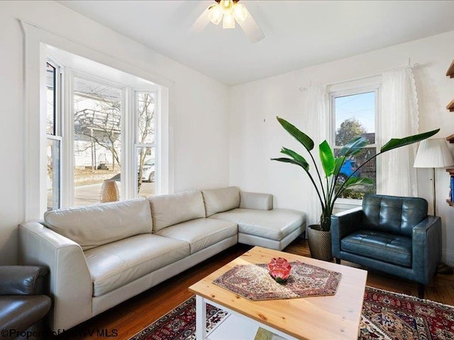 living area featuring dark wood-type flooring and a ceiling fan