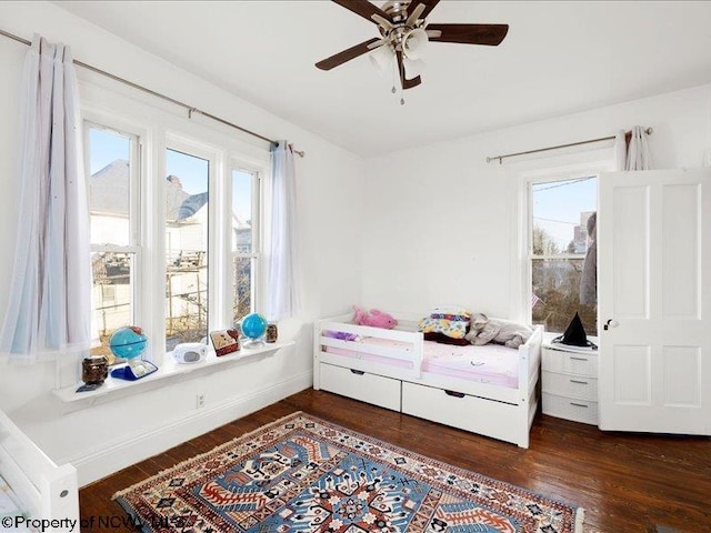 bedroom with ceiling fan, baseboards, and wood finished floors