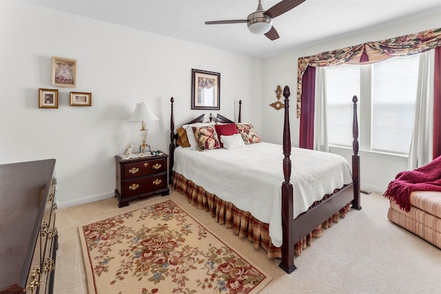 bedroom with a ceiling fan, light carpet, and baseboards