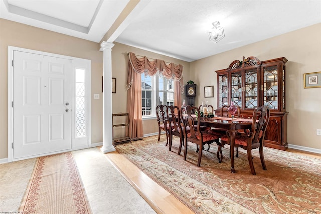 dining area with baseboards and ornate columns