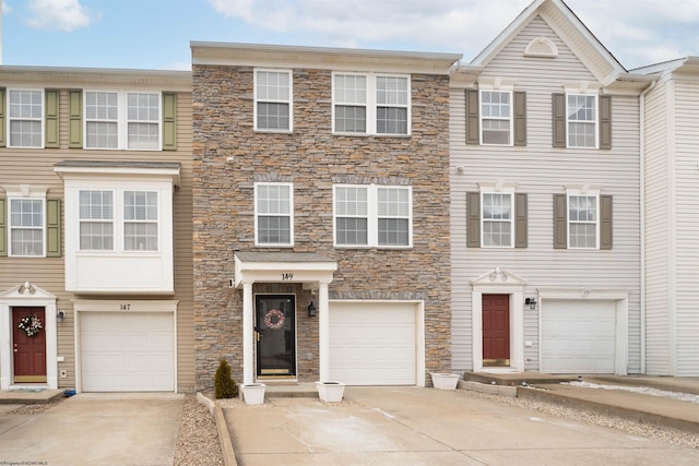 view of property with a garage and concrete driveway